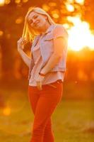 jovem mulher no campo ao pôr do sol foto