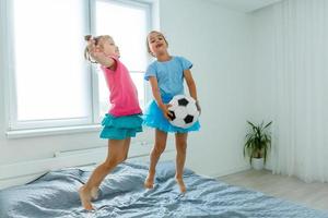 meninas com bola de futebol em casa foto