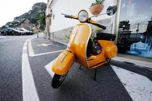 Scooter vespa amarelo vintage de 1964 na estrada de positano, itália. foto