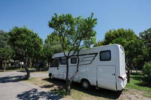 viajar rv estacionamento no parque, viagem de férias em motorhome, carro de caravana de férias. foto