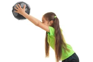 menina em uniforme esportivo jogando com bola de futebol foto