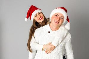 casal apaixonado comemora o natal com chapéu de papai noel foto