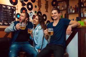 pessoas divertidas no bar olhando para longe, bebendo e rindo foto