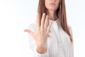 garota de camisa branca segurando uma mão na sua frente e mostra os cinco dedos do pé foto