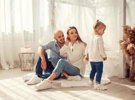 família jovem em casa no quarto ltgh com sua filha foto