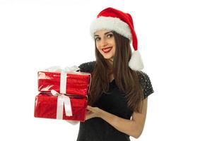 menina bonita com chapéu de Papai Noel com presente vermelho foto