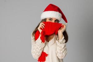 menina de chapéu de papai noel e lenço vermelho foto