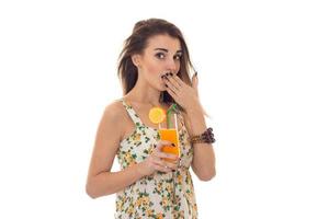 linda garota fecha a boca e a mão segura na mão um copo de suco de fruta foto