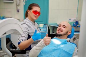 feliz médico e paciente em um consultório odontológico sorrindo