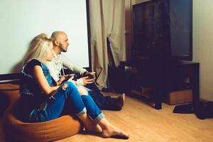 jovem casal de beleza se divertindo e jogando jogos de computador na tv foto