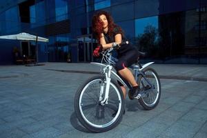 mulher morena alegre dos esportes em uma bicicleta foto