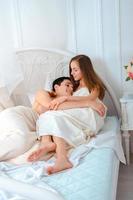 jovem casal apaixonado deitado na cama foto