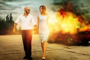 homem e uma mulher fogem de carro em chamas foto