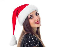 alegre menina morena com chapéu de Papai Noel foto