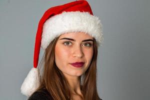 close-up da menina de beleza com chapéu de Papai Noel foto