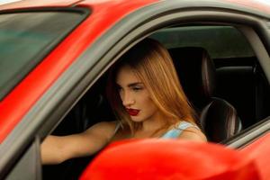 mulher com lábios vermelhos dirigindo um carro foto