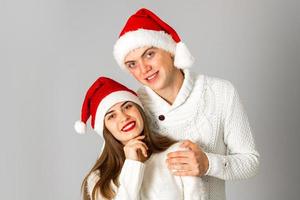 casal apaixonado comemora o natal com chapéu de papai noel foto