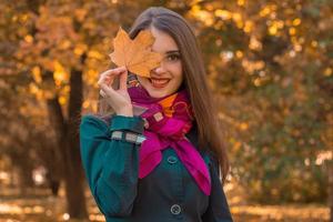 linda garota atraente no lenço rosa mantém o lençol perto dos olhos e sorri foto