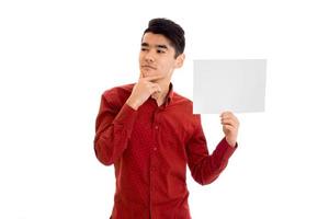 jovem elegante modelo masculino pensativo posando com cartaz nas mãos, isolado no fundo branco foto