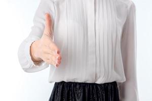 garota de camisa branca fica em pé e estica a mão para a frente closeup foto