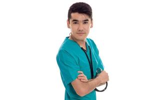 belo jovem médico masculino com estetoscópio em uniforme posando isolado no fundo branco foto