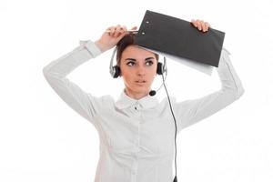 jovem de camisa branca e fones de ouvido com microfone olha para cima e levanta antes de um tablet foto