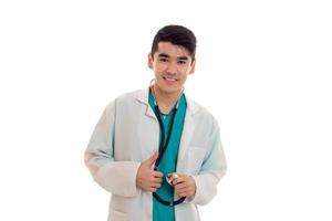 jovem atraente médico de uniforme azul com estetoscópio no pescoço isolado no fundo branco foto