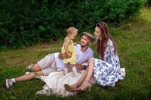 família alegre se divertindo no parque. pais com filha relaxando ao ar livre. foto