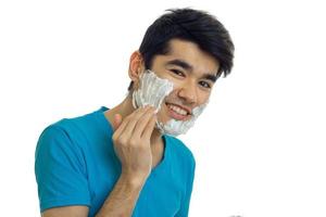 cara jovem bonito alegre colocando uma espuma de barba foto