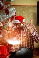 hipster surpreso abre um presente de natal foto