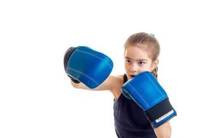 menina bonitinha praticando boxe em luvas azuis foto