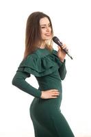 linda jovem de vestido verde cantando música foto