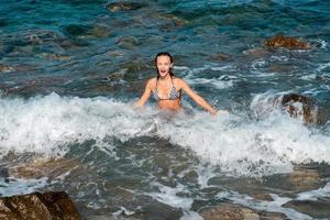 linda garota se divertindo no horário de verão do mar foto