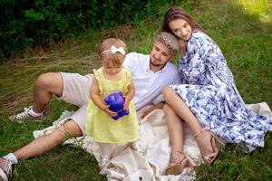 linda família com filha relaxante ao ar livre foto