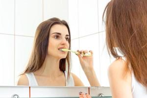 mulher escovando os dentes com uma escova antes de dormir foto