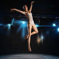 dançarina de balé em salto no palco do teatro foto