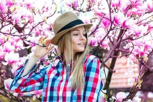 menina loira aproveitar a vida com flores por trás foto