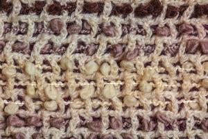 textura de fundo de um cachecol de lã bege quente com fios marrons. foto