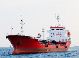 petroleiro vermelho está ancorado perto do porto foto