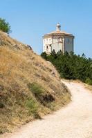 calascio, itália-9 de agosto de 2021-igreja de santa maria della pieta no caminho que leva a rocca calascio durante um dia ensolarado foto