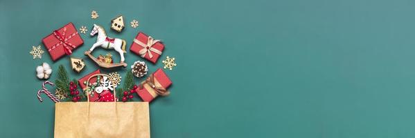 caixas de presente vermelhas embrulhadas à mão decoradas com fitas, flocos de neve e números, decorações de natal e decoração em saco na mesa verde conceito de calendário do advento de natal vista superior cartão de férias plano leigo foto