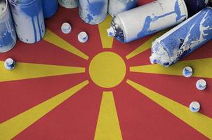 bandeira da macedônia e algumas latas de spray aerossol usadas para pintura de grafite. conceito de cultura de arte de rua foto