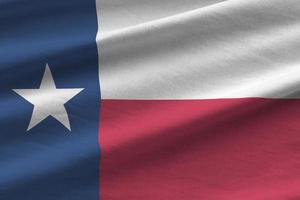 bandeira do estado do texas eua com grandes dobras acenando perto sob a luz do estúdio dentro de casa. os símbolos e cores oficiais no banner foto