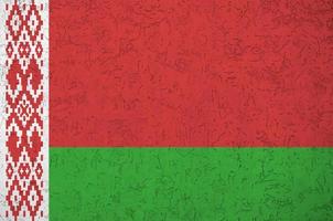 bandeira da bielorrússia retratada em cores de tinta brilhante na parede de reboco em relevo antigo. banner texturizado em fundo áspero foto