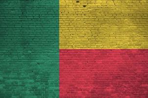 bandeira do benin retratada em cores de tinta na parede de tijolos antigos. banner texturizado em fundo de alvenaria de parede de tijolo grande foto