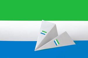 bandeira da serra leoa retratada no avião de origami de papel. conceito de artes artesanais foto