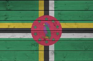 bandeira dominica retratada em cores de tinta brilhante na parede de madeira velha. banner texturizado em fundo áspero foto