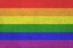 bandeira da comunidade lgbt retratada em cores de tinta brilhante na parede de reboco em relevo antigo. banner texturizado em fundo áspero foto