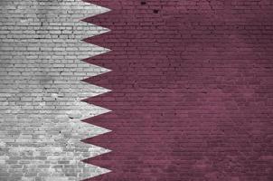 bandeira do qatar retratada em cores de tinta na parede de tijolos antigos. banner texturizado em fundo de alvenaria de parede de tijolo grande foto