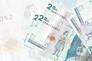 Notas de 2 pesos colombianos estão na pilha no fundo da grande nota semitransparente. apresentação abstrata da moeda nacional foto
